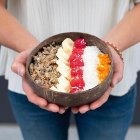 bowl of granola, banads, raspberries and coconut meat